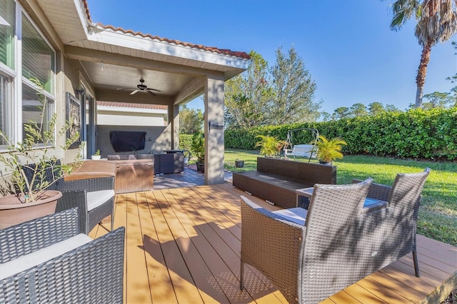 wooden terrace featuring an outdoor hangout area, ceiling fan, and a lawn