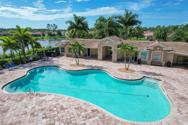 view of pool featuring a patio area and a water view