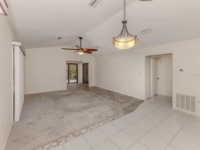 unfurnished living room with ceiling fan, light tile patterned flooring, lofted ceiling, and a textured ceiling