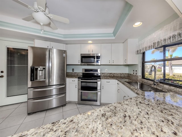 kitchen featuring a tray ceiling, sink, white cabinets, and appliances with stainless steel finishes