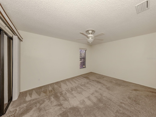 unfurnished bedroom featuring a textured ceiling, ceiling fan, and light carpet