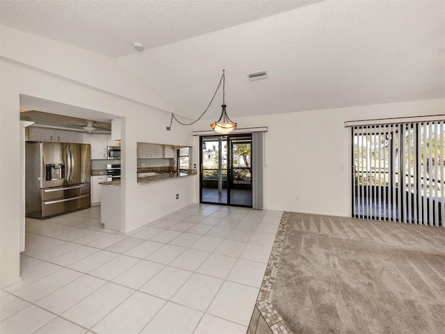 tiled empty room featuring a textured ceiling and lofted ceiling