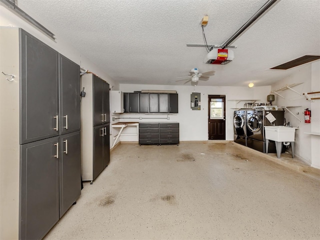 garage with ceiling fan, sink, separate washer and dryer, electric panel, and a garage door opener