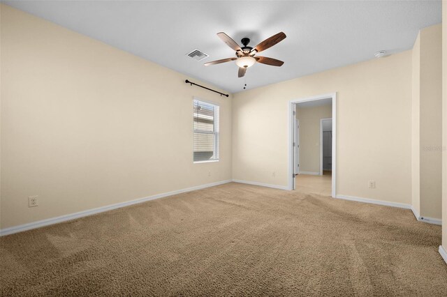 carpeted spare room featuring ceiling fan