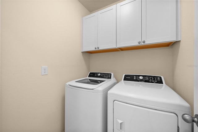 laundry room with washer and clothes dryer and cabinets