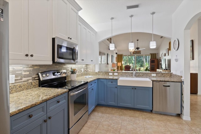 kitchen with stainless steel appliances, ceiling fan, sink, white cabinets, and lofted ceiling