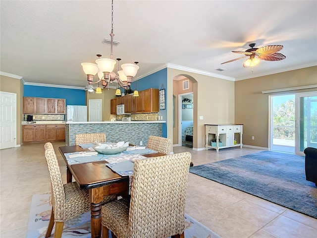 tiled dining room featuring ceiling fan with notable chandelier and ornamental molding