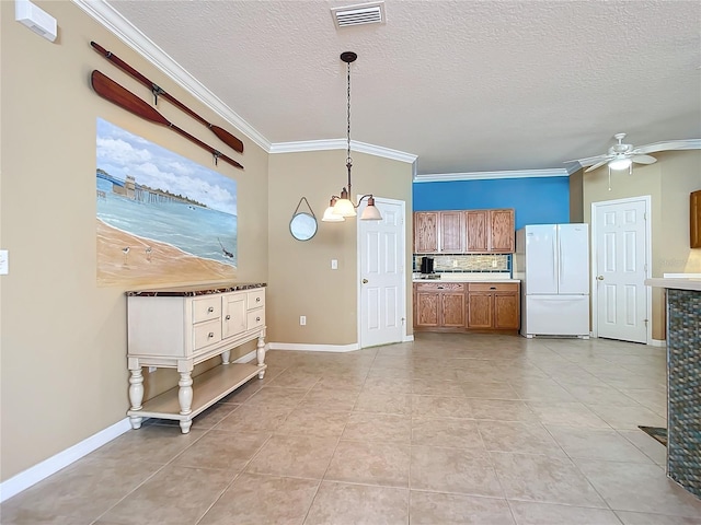5255 Athens Way, Venice, FL 34293 - kitchen featuring freestanding refrigerator, brown cabinets, ceiling fan, crown molding, and light countertops