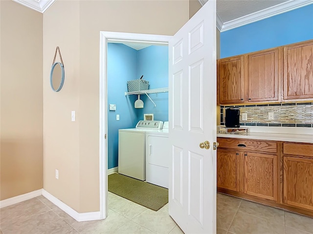 laundry area with light tile patterned floors, laundry area, ornamental molding, and independent washer and dryer