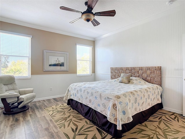5255 Athens Way, Venice, FL 34293 - bedroom with crown molding, wood finished floors, multiple windows, a wainscoted wall, and a ceiling fan