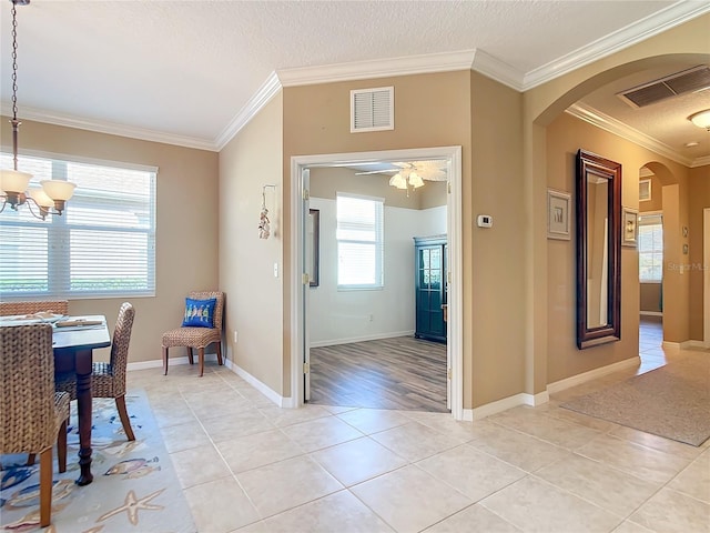 5255 Athens Way, Venice, FL 34293 - dining space featuring arched walkways, ornamental molding, light tile patterned flooring, a chandelier, and a textured ceiling