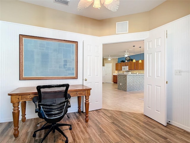 office space featuring light wood-style floors, visible vents, and ceiling fan