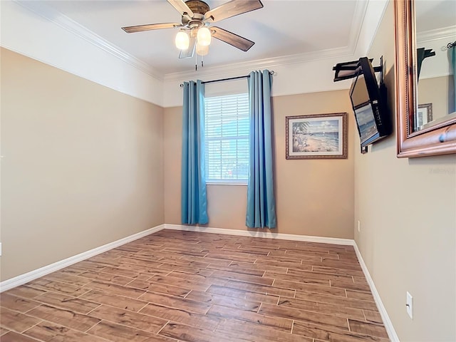 empty room with baseboards, wood finished floors, a ceiling fan, and crown molding