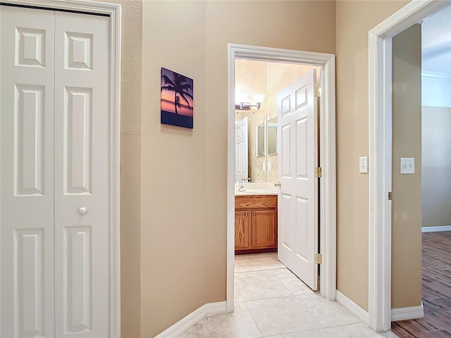 hallway with baseboards and light tile patterned floors