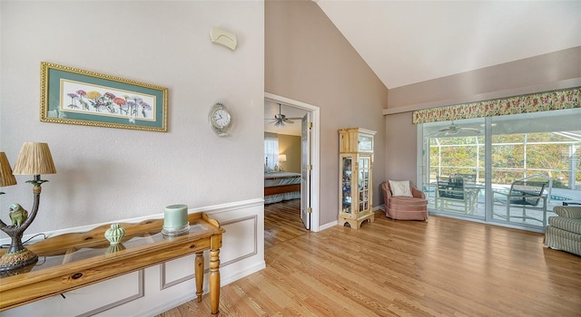 sitting room with light hardwood / wood-style floors and high vaulted ceiling