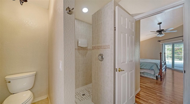 bathroom with a tile shower, ceiling fan, lofted ceiling, toilet, and hardwood / wood-style flooring