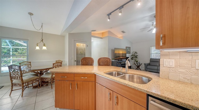 kitchen with decorative backsplash, vaulted ceiling, ceiling fan, sink, and dishwasher