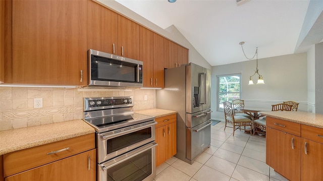 kitchen with stainless steel appliances, backsplash, a chandelier, vaulted ceiling, and light tile patterned flooring