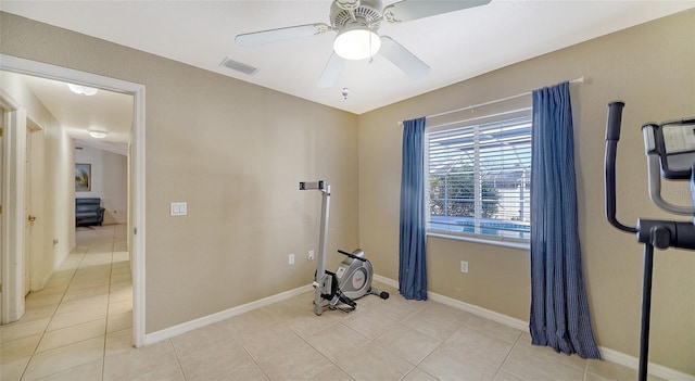 exercise room featuring light tile patterned floors and ceiling fan