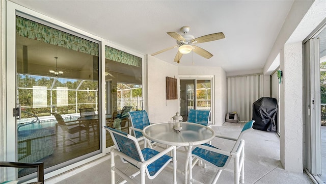 sunroom / solarium with ceiling fan with notable chandelier