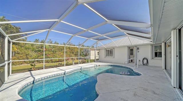 view of pool with glass enclosure and a patio