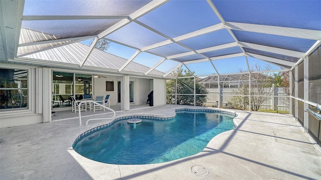 view of pool with glass enclosure, ceiling fan, and a patio