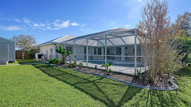 rear view of house featuring a yard, a fenced in pool, and glass enclosure