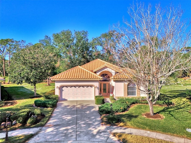 mediterranean / spanish-style home with a front yard and a garage