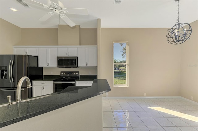 kitchen featuring ceiling fan, stainless steel appliances, light tile patterned floors, pendant lighting, and white cabinets