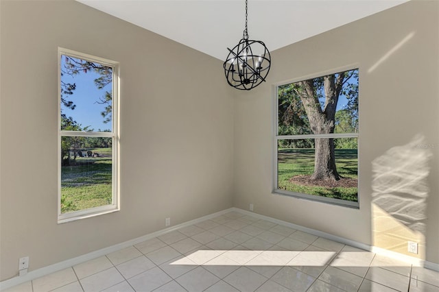 spare room with light tile patterned floors and a chandelier