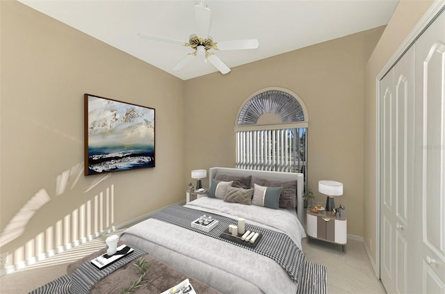 bedroom with ceiling fan, light colored carpet, and a closet