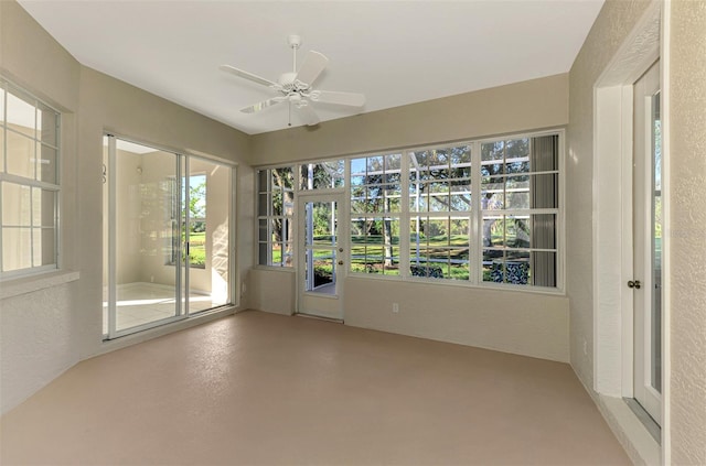 unfurnished sunroom with ceiling fan