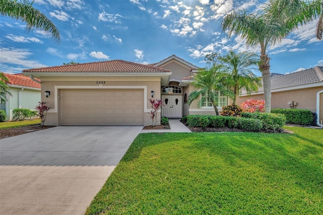 mediterranean / spanish house featuring a front yard and a garage