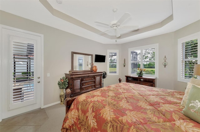 tiled bedroom featuring a raised ceiling, ceiling fan, and access to exterior