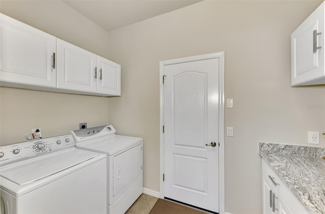 laundry area with cabinets, tile patterned floors, and washing machine and clothes dryer