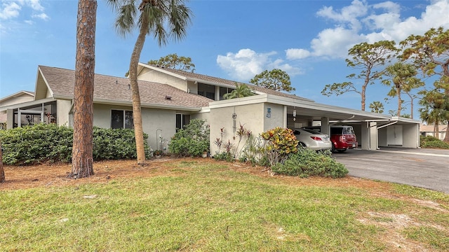 view of front of property featuring a front lawn and a carport