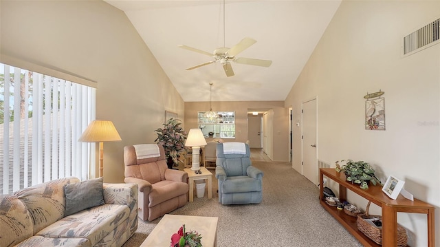 living room featuring high vaulted ceiling, light colored carpet, and ceiling fan with notable chandelier