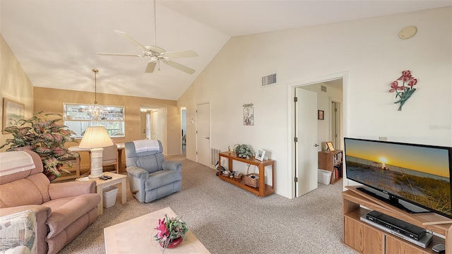 carpeted living room with ceiling fan with notable chandelier and high vaulted ceiling