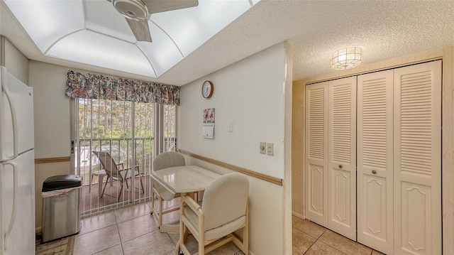 tiled dining area featuring ceiling fan and a textured ceiling