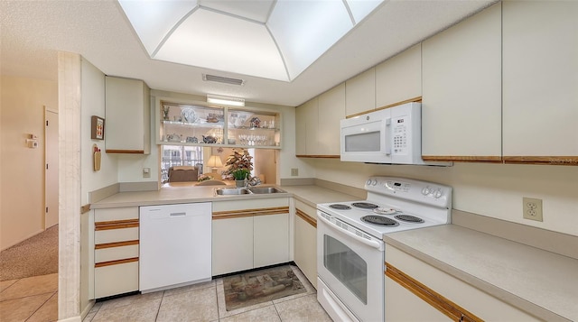 kitchen featuring white cabinetry, sink, light tile patterned floors, and white appliances