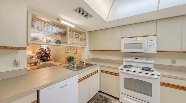 kitchen featuring kitchen peninsula, a textured ceiling, white appliances, sink, and white cabinets