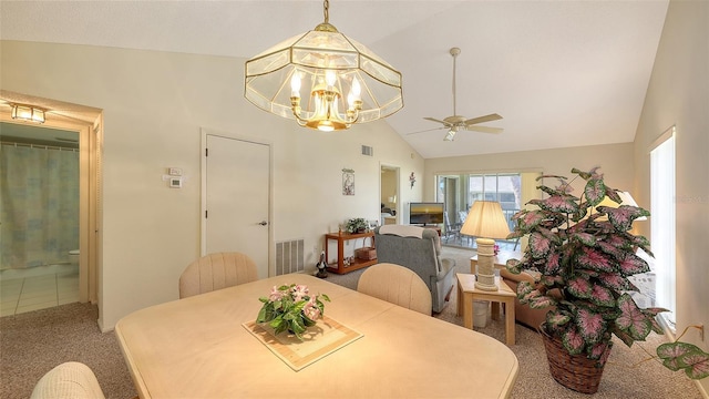 carpeted dining area featuring ceiling fan with notable chandelier and vaulted ceiling