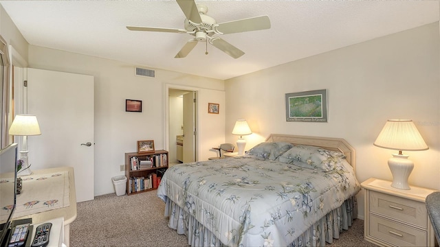 carpeted bedroom featuring ceiling fan and a textured ceiling