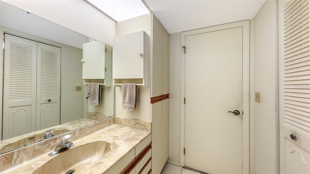 bathroom featuring tile patterned floors, vanity, and a textured ceiling