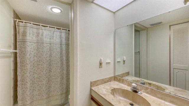 bathroom featuring curtained shower, vanity, and toilet