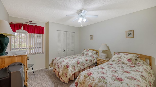 carpeted bedroom featuring ceiling fan, a closet, and a textured ceiling