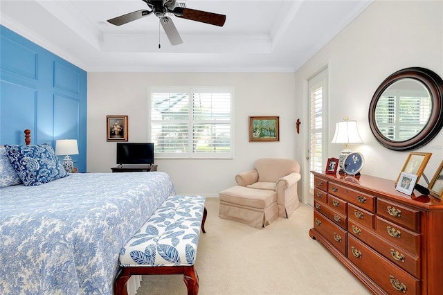 carpeted bedroom with a tray ceiling, multiple windows, and ceiling fan