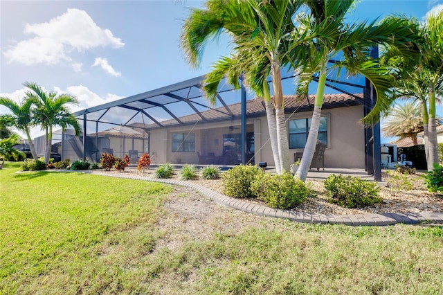 back of house with a lawn and a lanai