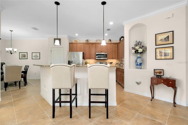 kitchen with a center island, crown molding, appliances with stainless steel finishes, decorative light fixtures, and light stone counters