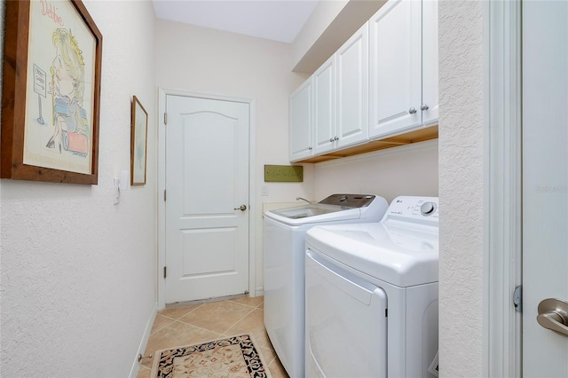 laundry room featuring cabinets, washer and dryer, and light tile patterned flooring